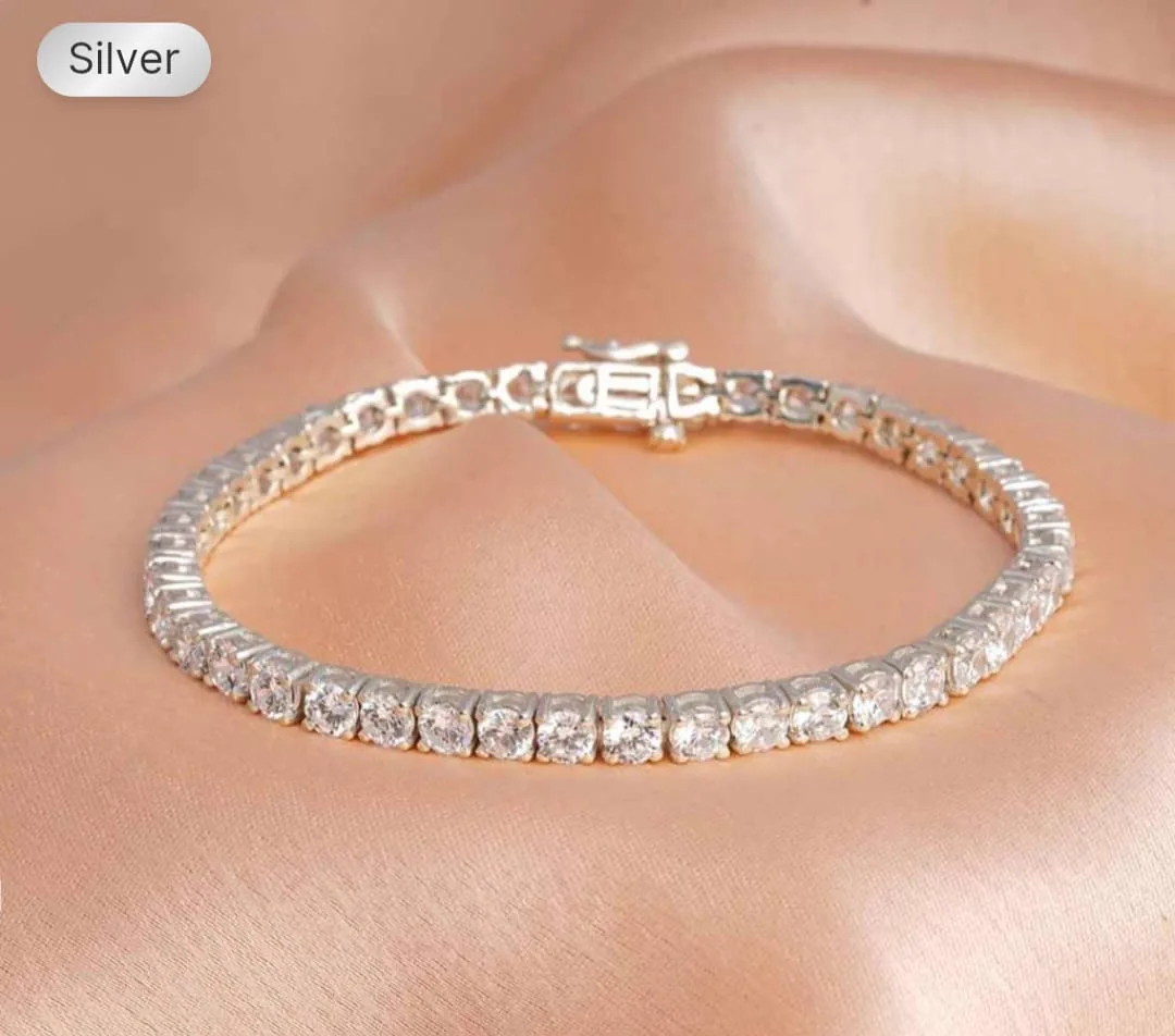The reference photo uploaded to Nitaris: a silver cubic-zirconia tennis bracelet, flat on peach silk